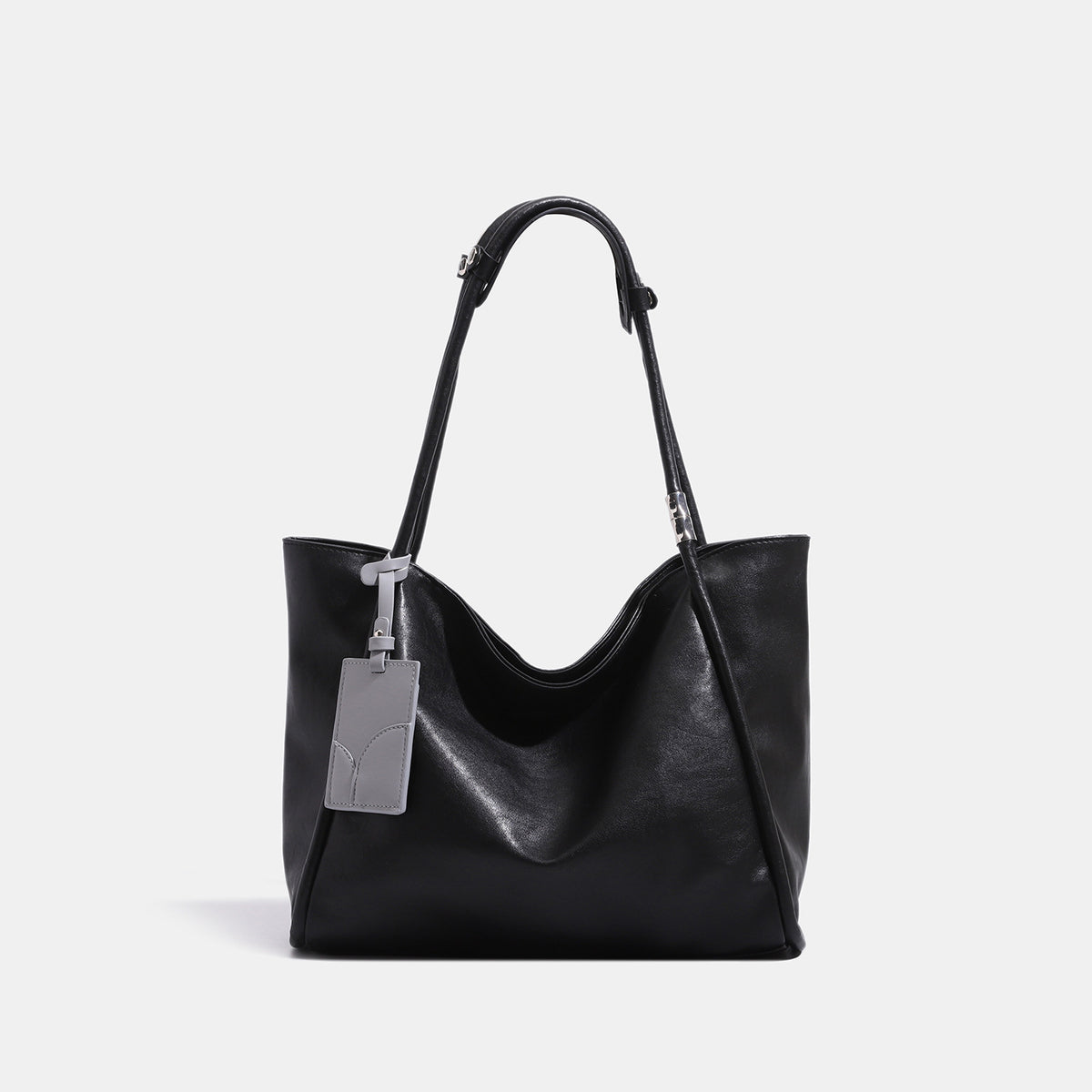 Soft slouchy leather-look tote shoulder bag with long straps, silver-tone hardware, and gray hanging tag, front view