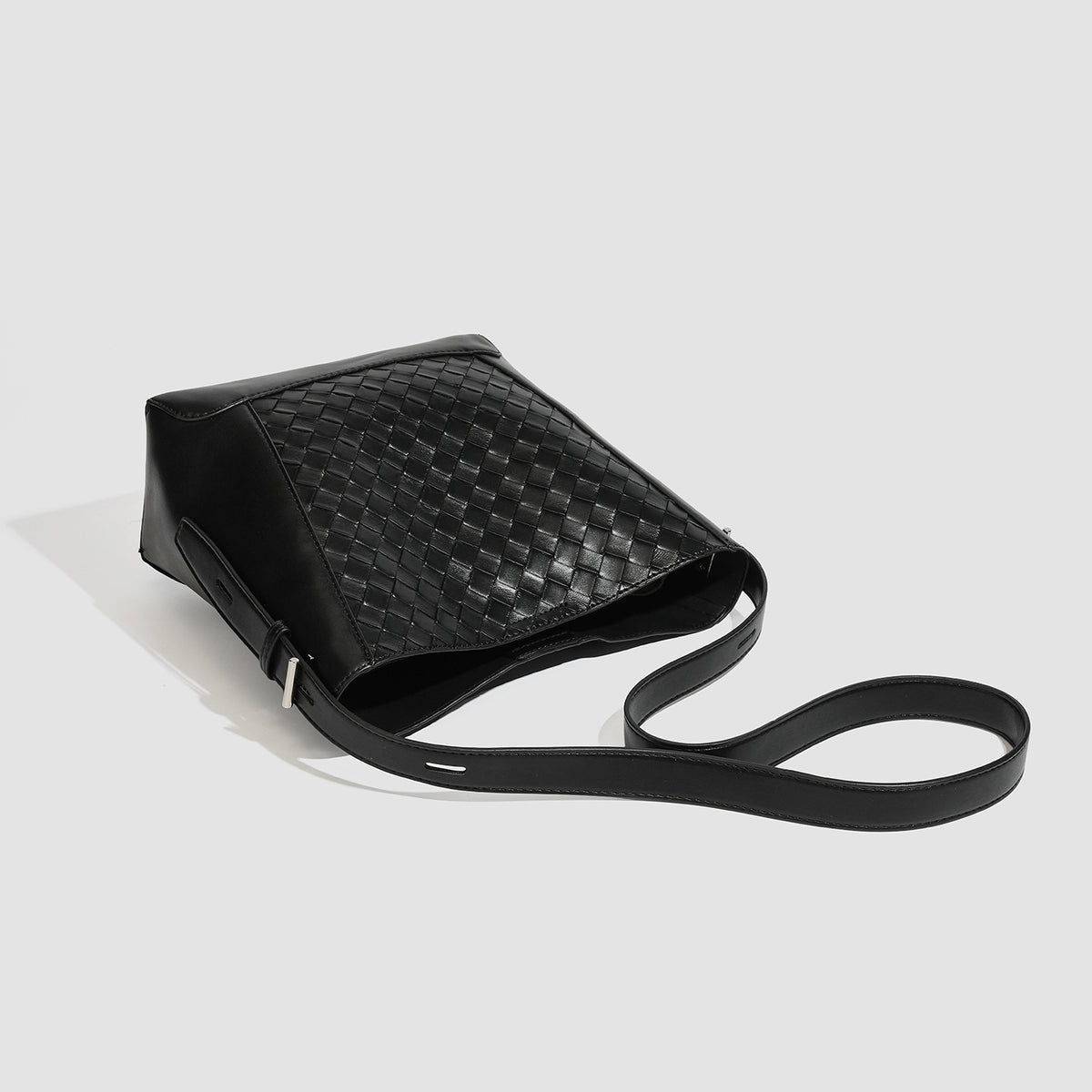 Large black bucket shoulder bag with diamond woven leather-look front panel, smooth side panels, magnetic snap closure, and