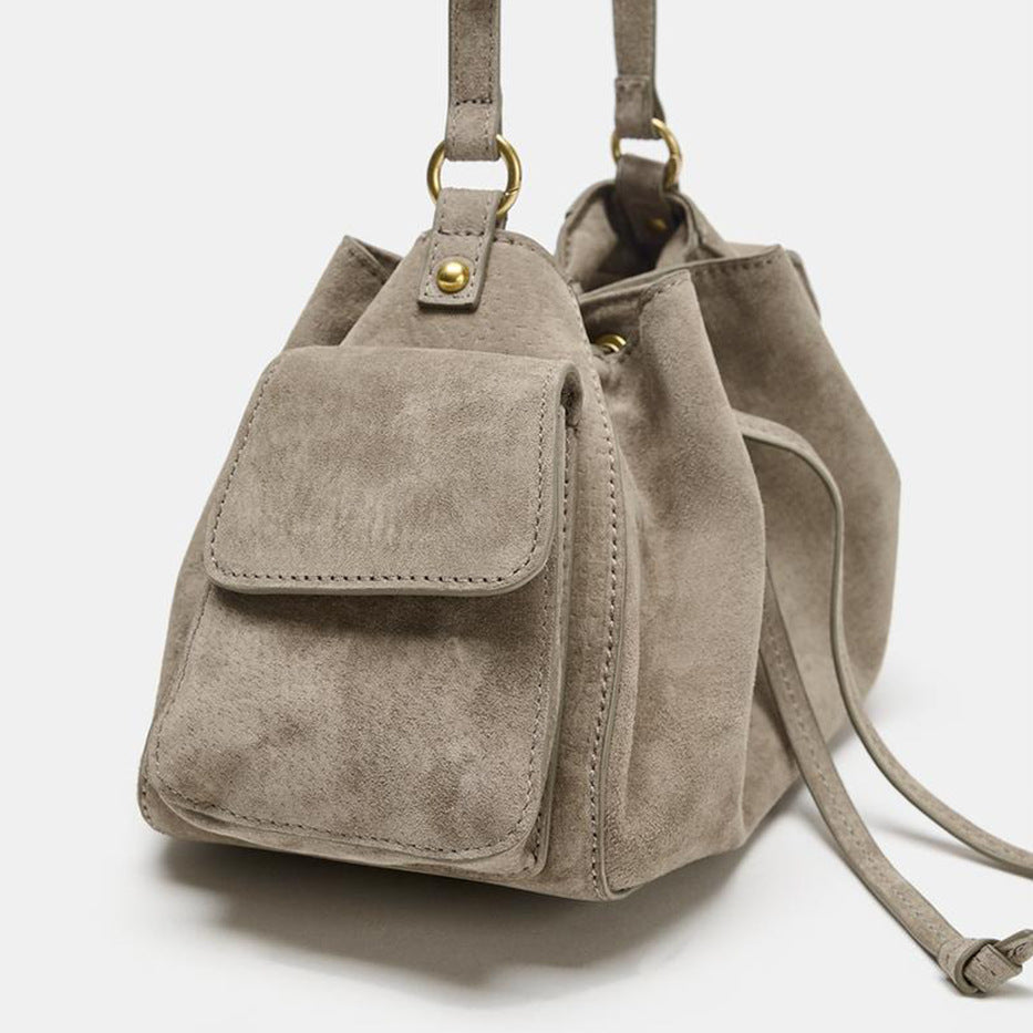 Weiche Beuteltasche in Taupe in Velourslederoptik mit seitlichen Taschen mit Überschlag, Beschlägen in Antikgoldoptik und verstellbarem Crossbody-Riemen