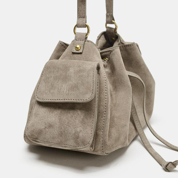 Weiche Beuteltasche in Taupe in Velourslederoptik mit seitlichen Taschen mit Überschlag, Beschlägen in Antikgoldoptik und verstellbarem Crossbody-Riemen