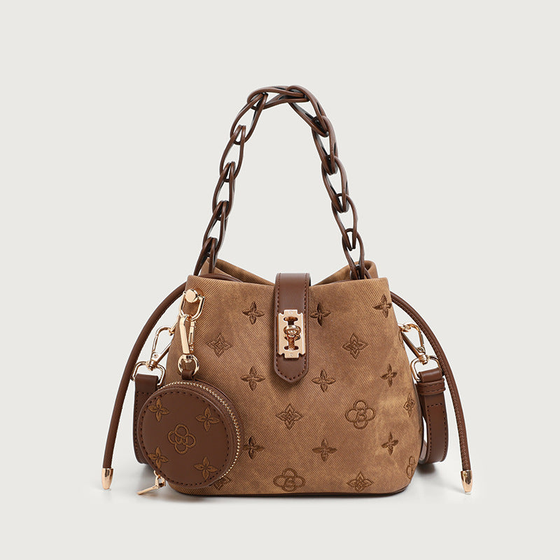 Kompakte Beuteltasche mit geprägtem Monogramm, geflochtenem Kettentragegriff, goldfarbenem Schlossverschluss und befestigtem rundem Münzfach, Detailansicht