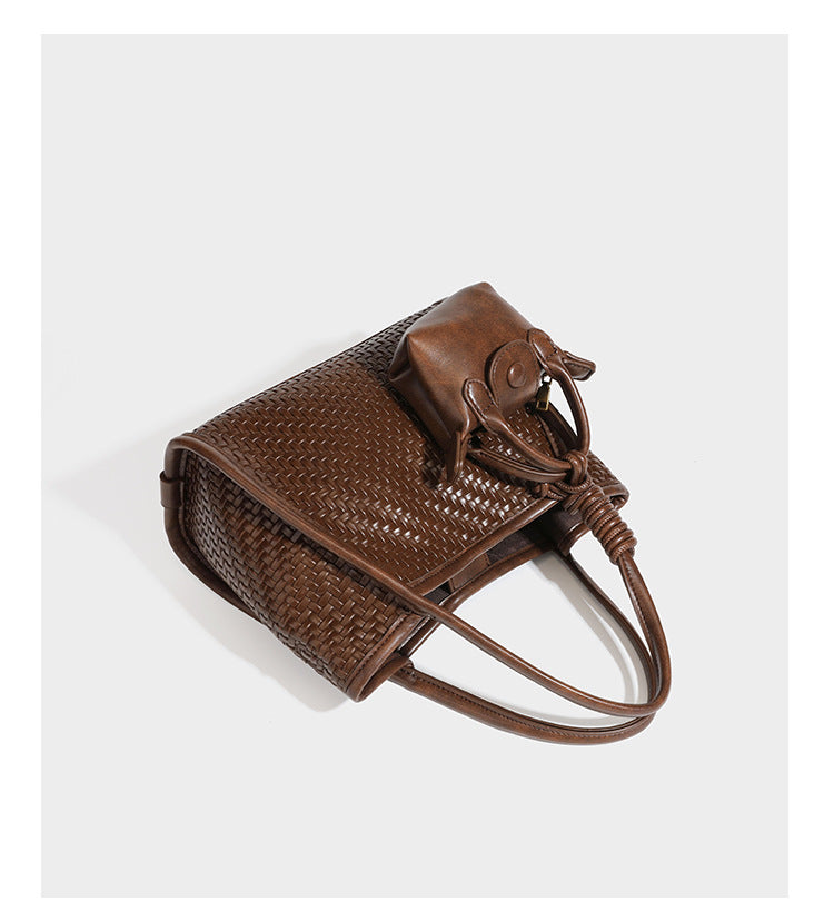 Strukturierte Tote-Bag mit Webstruktur in Braun, glattem, lederähnlichem Besatz, geknoteten Tragegriffen und einer befestigten Mini-Beuteltasche mit Kordelzug