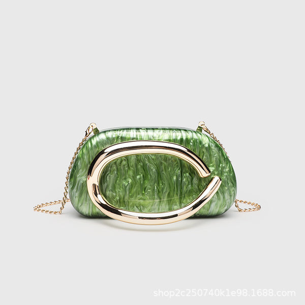 Kleine rechteckige Crossbody-Clutch mit abgerundeten Ecken, oversized poliertem C-förmigem Goldgriff und schmalem Goldkettenriemen, Detailansicht
