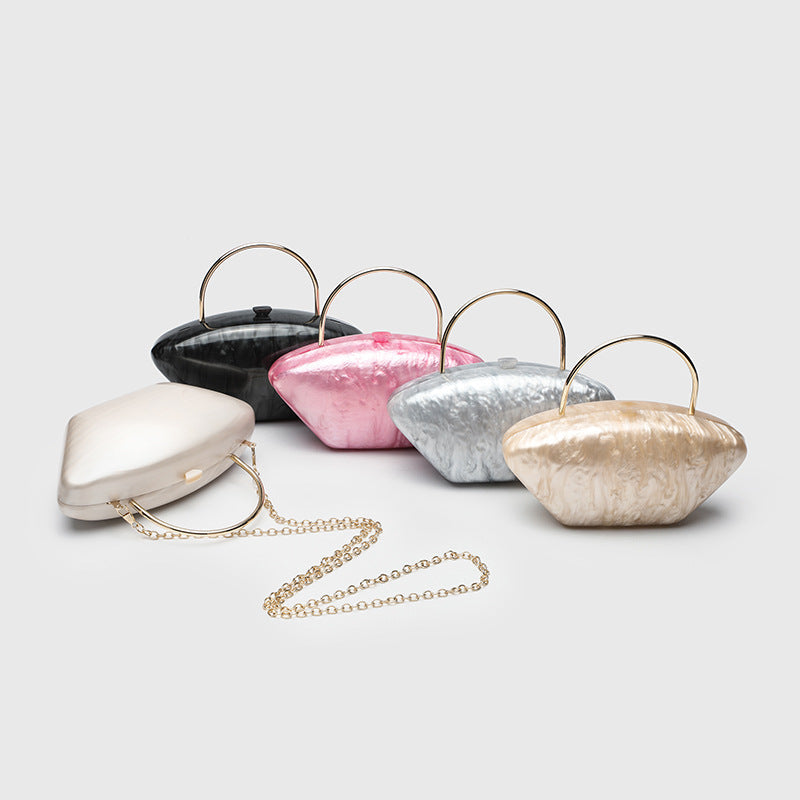 Shell-shaped pearlescent top-handle clutch bag with arched gold-tone metal handle and gold chain strap, detail view 3