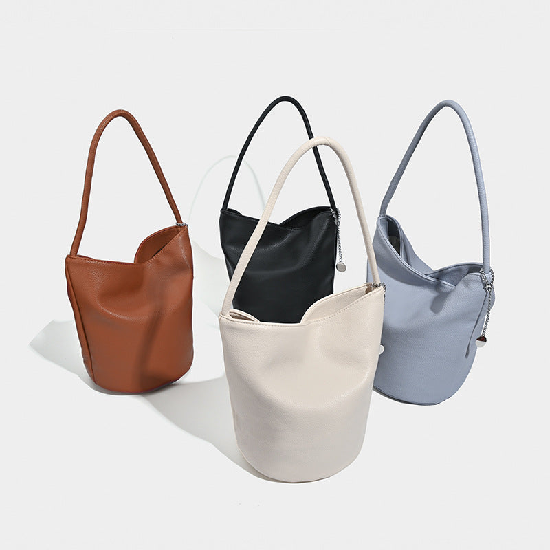 Bucket-Schultertasche aus genarbter Lederoptik mit Ketten- und Scheibenanhänger-Beschlägen sowie einem einzelnen geschwungenen Tragegriff, Detailansicht 2