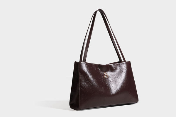 Strukturierte rechteckige Tote-Schultertasche aus glänzender, geknitterter Lederoptik mit langen Doppelträgern und Emblem in Goldoptik