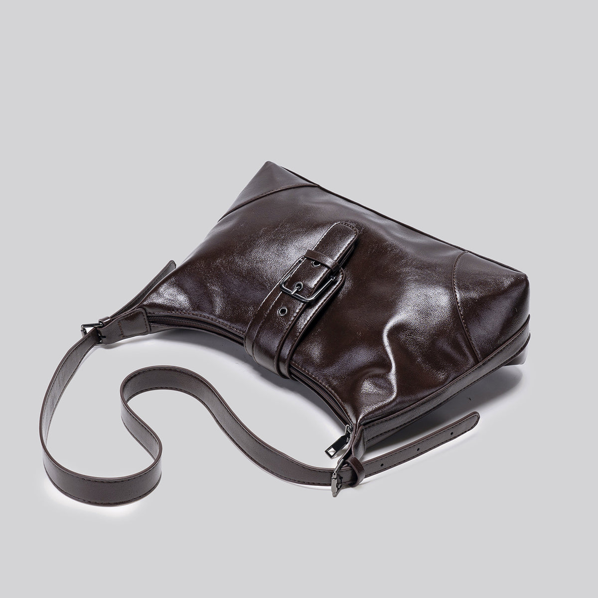 Glossy dark brown slouch hobo shoulder bag with front buckle strap panel and long adjustable single strap, detail view 4