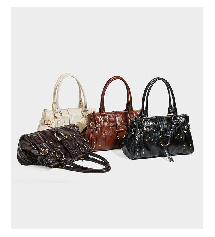Dark brown glossy leather-look structured satchel tote with gold-tone studs, buckle straps, dual top handles, and detachable
