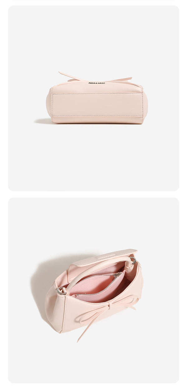 Structured mini trapezoid top-handle crossbody bag with sculpted bow front detail, smooth matte finish, silver-tone hardware