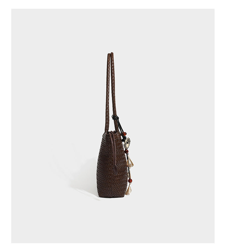 Structured woven leather-look tote bag in dark brown with long shoulder straps, side drawstring ties, and gold filigree
