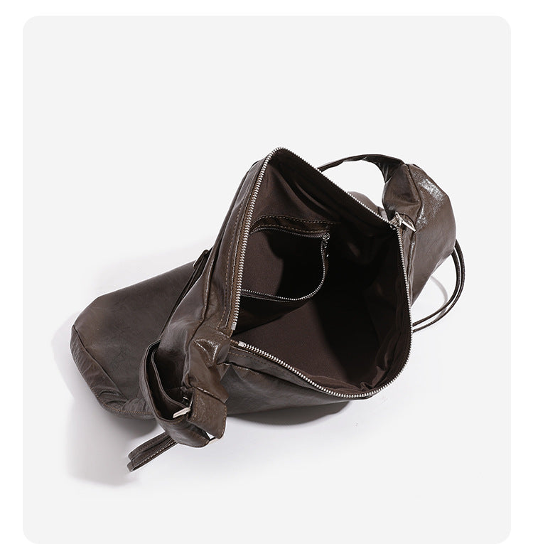 Oversized slouchy hobo shoulder bag with glossy crinkled leather-look finish, drawstring gathered sides, and silver-tone