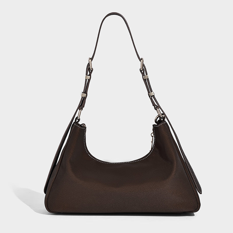 Crescent hobo shoulder bag in pebbled leather-look finish with top zipper, adjustable strap, gold-tone ring hardware, and