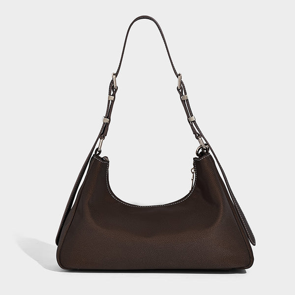 Crescent hobo shoulder bag in pebbled leather-look finish with top zipper, adjustable strap, gold-tone ring hardware, and