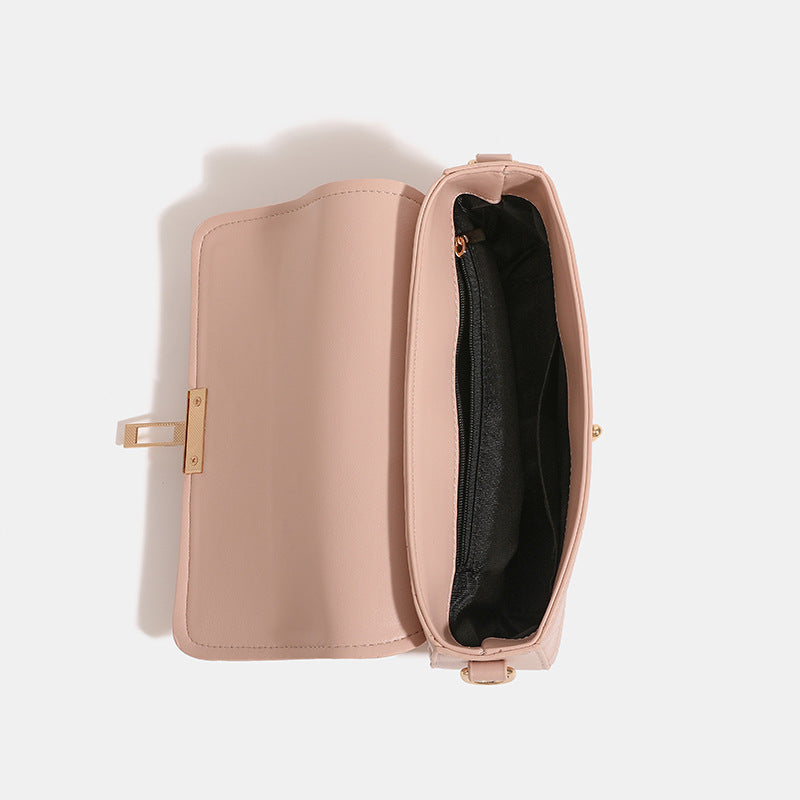 Small crocodile-embossed flap crossbody bag with circular gold turn-lock closure and chain strap, detail view 4