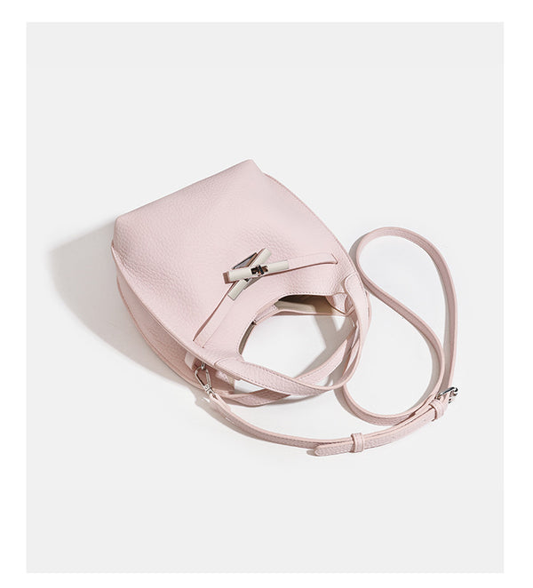 Compact pebbled leather-look shoulder bag with crossed silver-toned metal front closure, short top handle, and long, detail