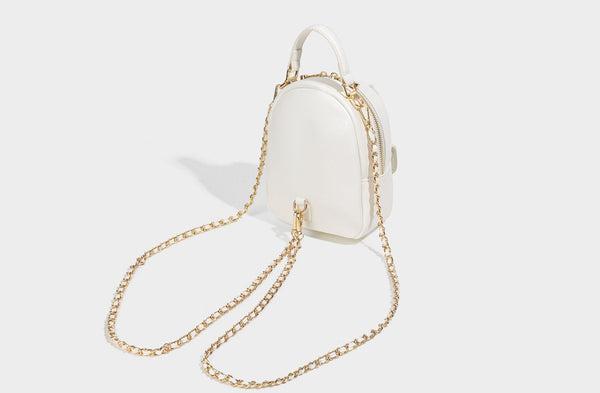 Structured mini backpack handbag with butterfly embroidery, gold-tone chain strap, and turn-lock front flap pocket, detail