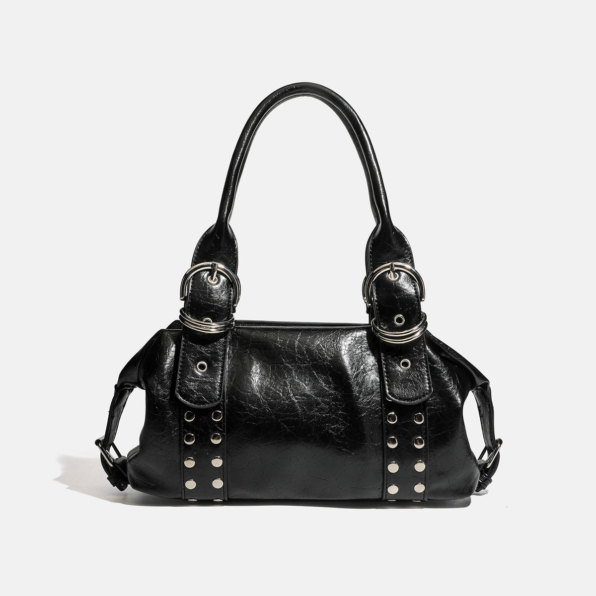 Compact black glossy leather-look satchel bag with silver-tone rivets, buckle hardware, and dual padded top handles, detail