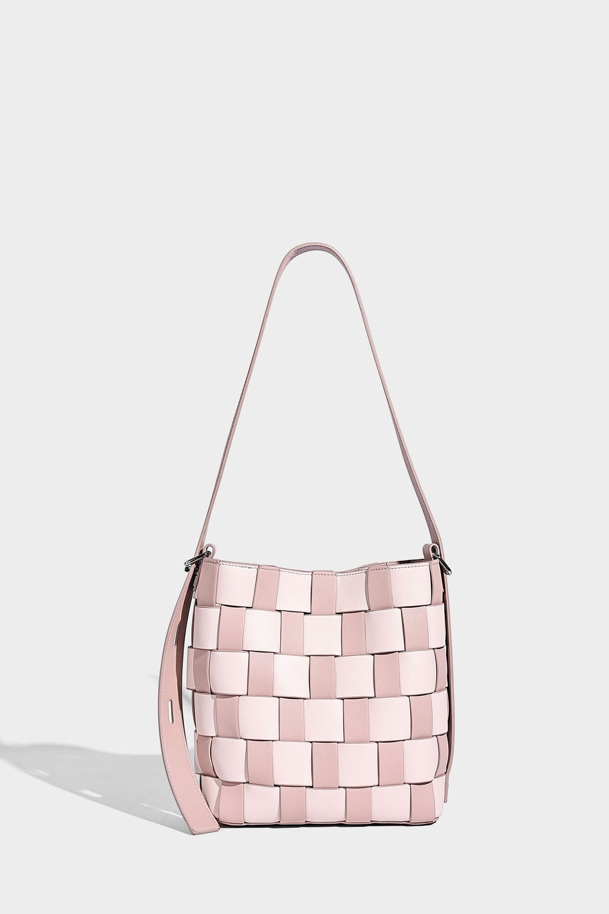 Hand-woven black-and-white checkerboard bucket bag with smooth black trim, silver-tone ring hardware, and adjustable