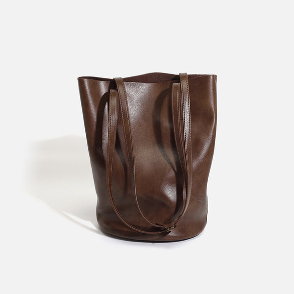 Large black smooth leather-look bucket tote bag with long shoulder straps and open top, front view