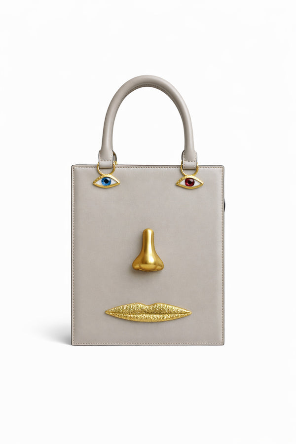 Structured rectangular top-handle bag in tan leather-look finish with gold-tone sculptural face hardware including