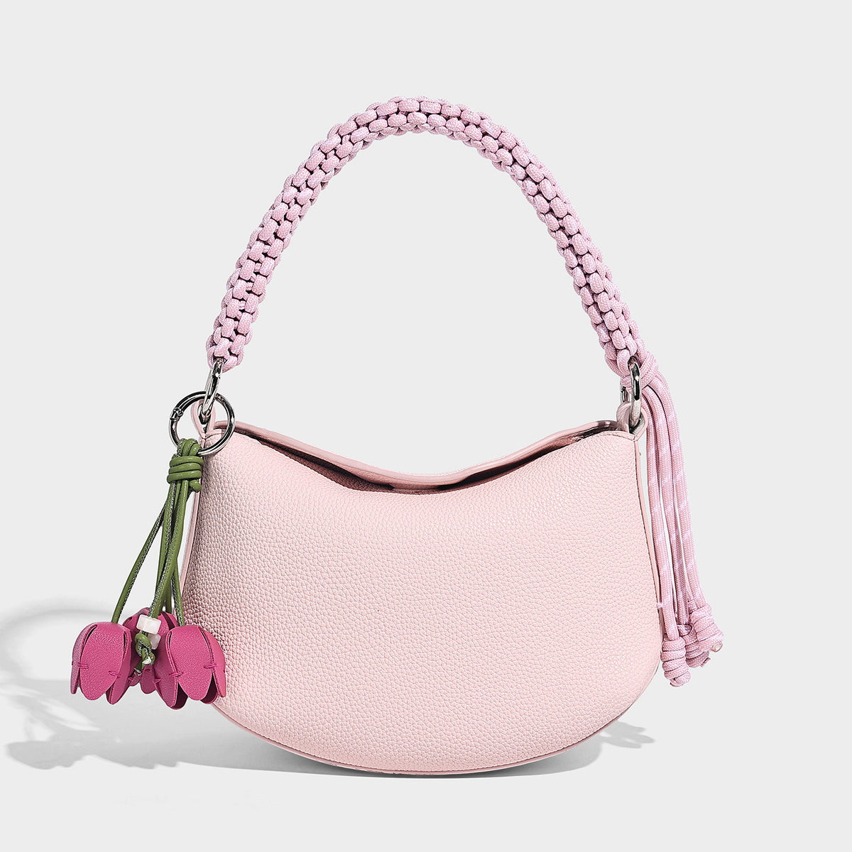 Small crescent half-moon bag in pebbled leather-look finish with braided top handle, silver-tone ring hardware, and, detail