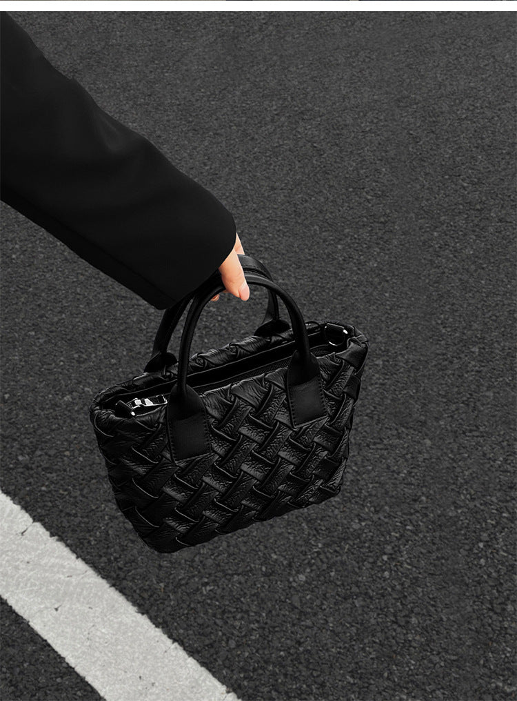 Small black glossy woven tote bag with dual top handles and detachable shoulder strap, detail view 8
