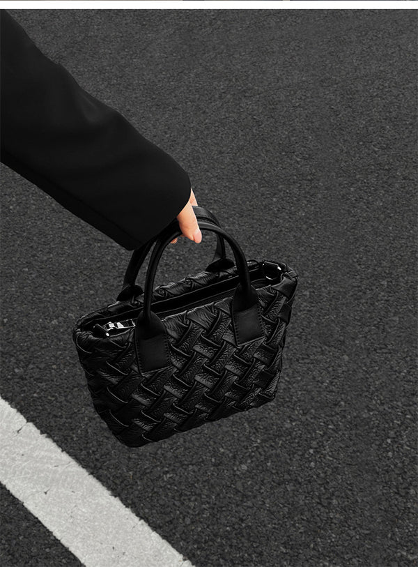 Small black glossy woven tote bag with dual top handles and detachable shoulder strap, detail view 8