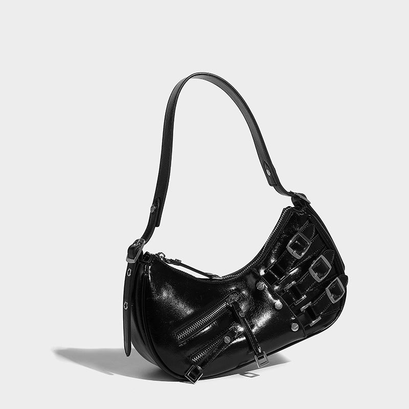 Crescent shoulder bag in washed blue denim-look PU with stacked buckle straps, front zip pocket, and silver-tone hardware