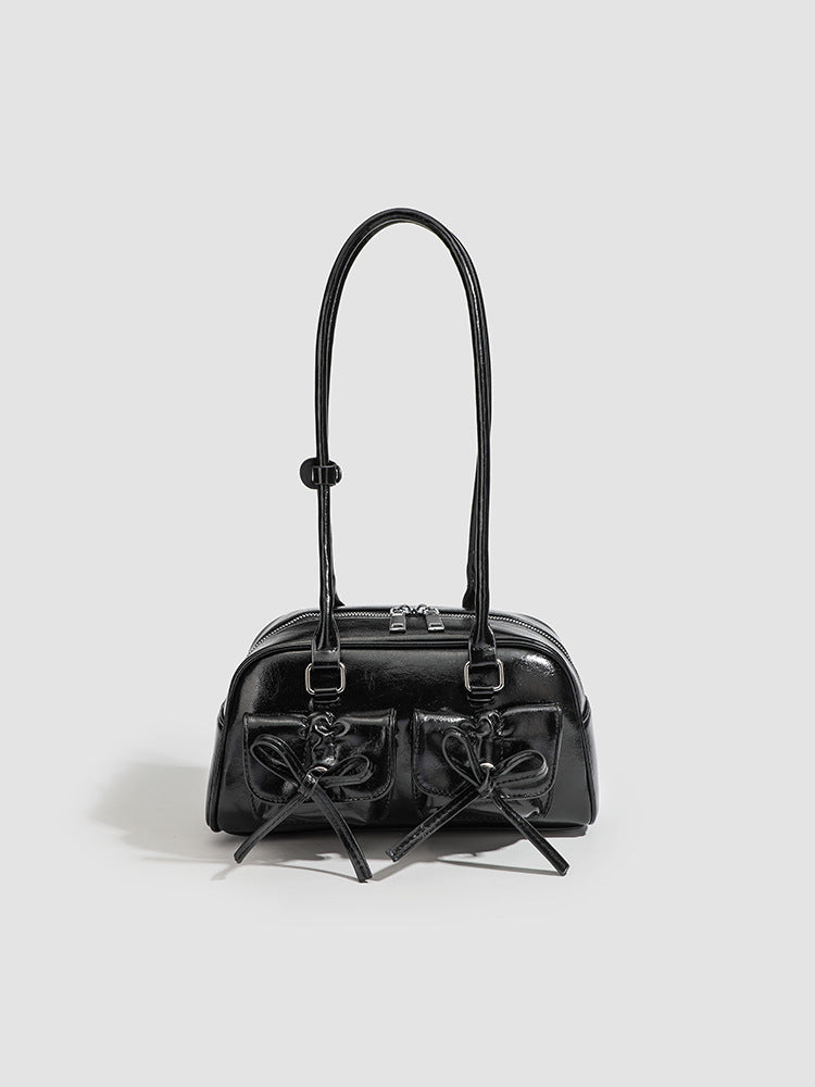 Kompakte Schultertasche aus glänzender Lederoptik mit vorderen Taschen und Schleifen-Kordelzug, Reißverschluss oben, zwei Tragegriffen und, Detailansicht