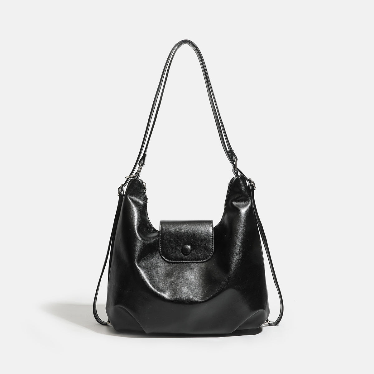 Lässig fallende Hobo-Schultertasche in glänzender Lederoptik mit vorderer Klappentasche und Druckknopf sowie silberfarbenen Metallbeschlägen, Vorderansicht