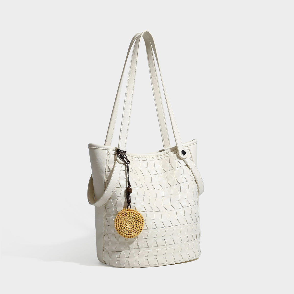 Brown embossed geometric woven leather-look bucket tote bag with dual shoulder straps, side snap hardware, and a round