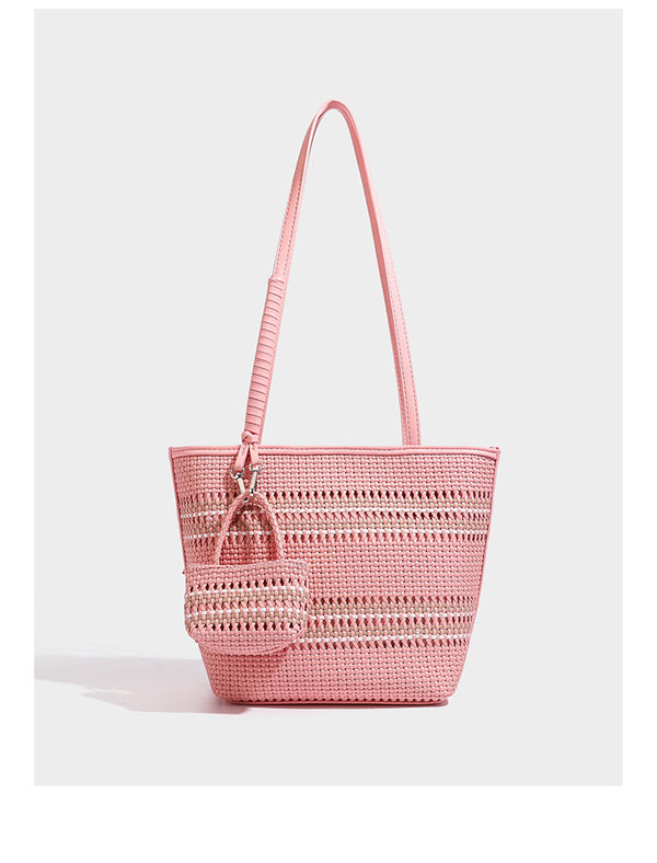 Large structured woven tote bag with striped basket-weave finish, long shoulder straps, and detachable mini pouch charm