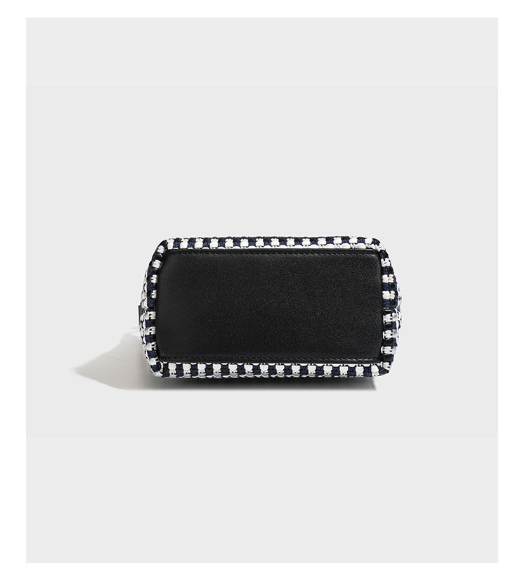 Small crescent shoulder bag in black-and-white woven textile with smooth black leather-look trim, zip-top closure, knotted