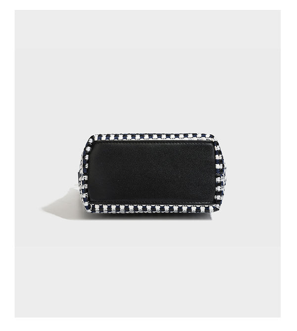 Small crescent shoulder bag in black-and-white woven textile with smooth black leather-look trim, zip-top closure, knotted