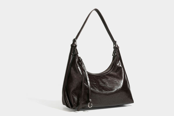 Slouchy hobo shoulder bag in glossy crinkled leather-look finish with zip-top closure and silver-tone ring hardware, detail