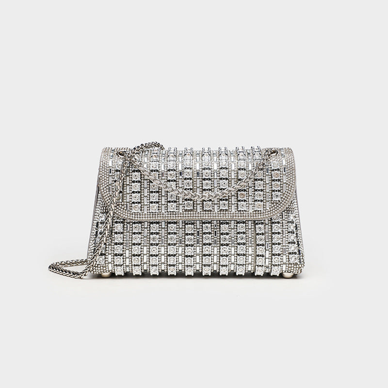 Structured mini flap crossbody bag covered in grid-set rhinestones with silver-tone chain strap, front view