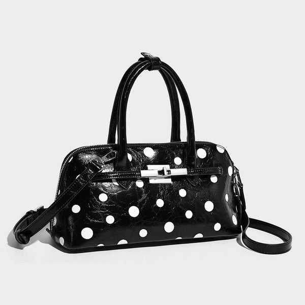 Glossy structured polka-dot satchel bag with dual top handles, silver turn-lock hardware, and detachable shoulder strap