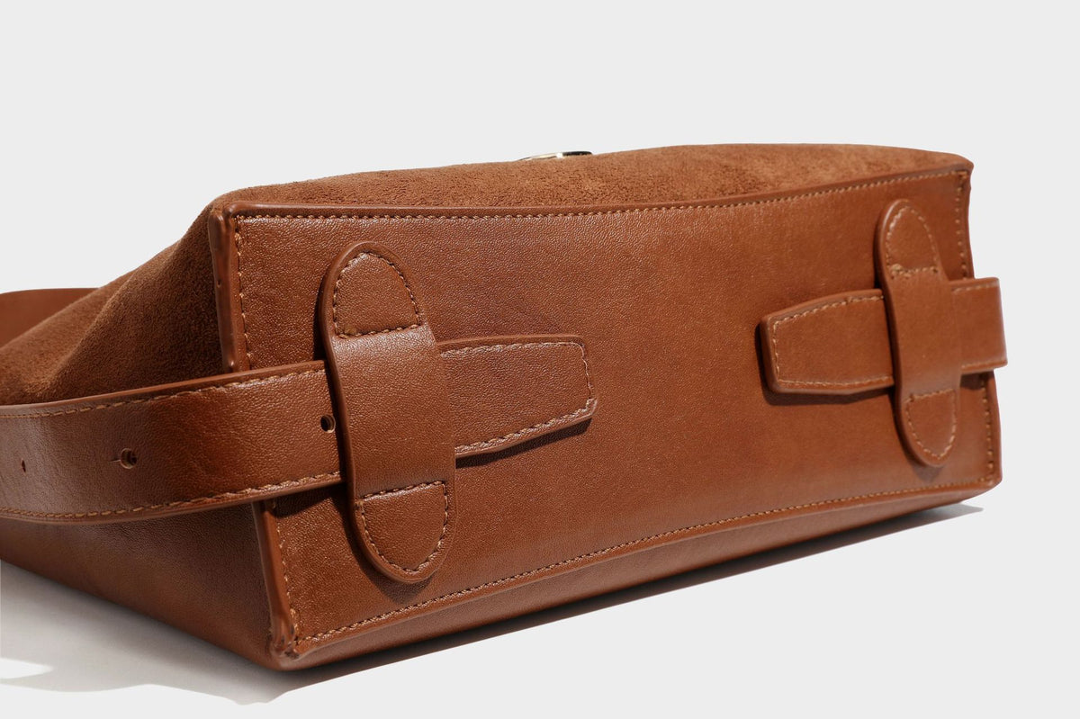 Slouchy suede-finish brown shoulder bag with long single strap and small gold-tone logo emblem on front, detail view 34