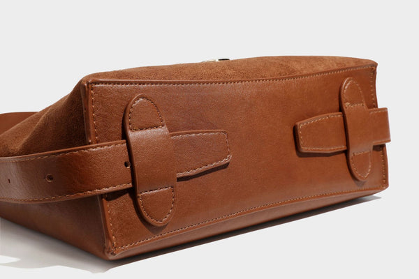 Slouchy suede-finish brown shoulder bag with long single strap and small gold-tone logo emblem on front, detail view 34
