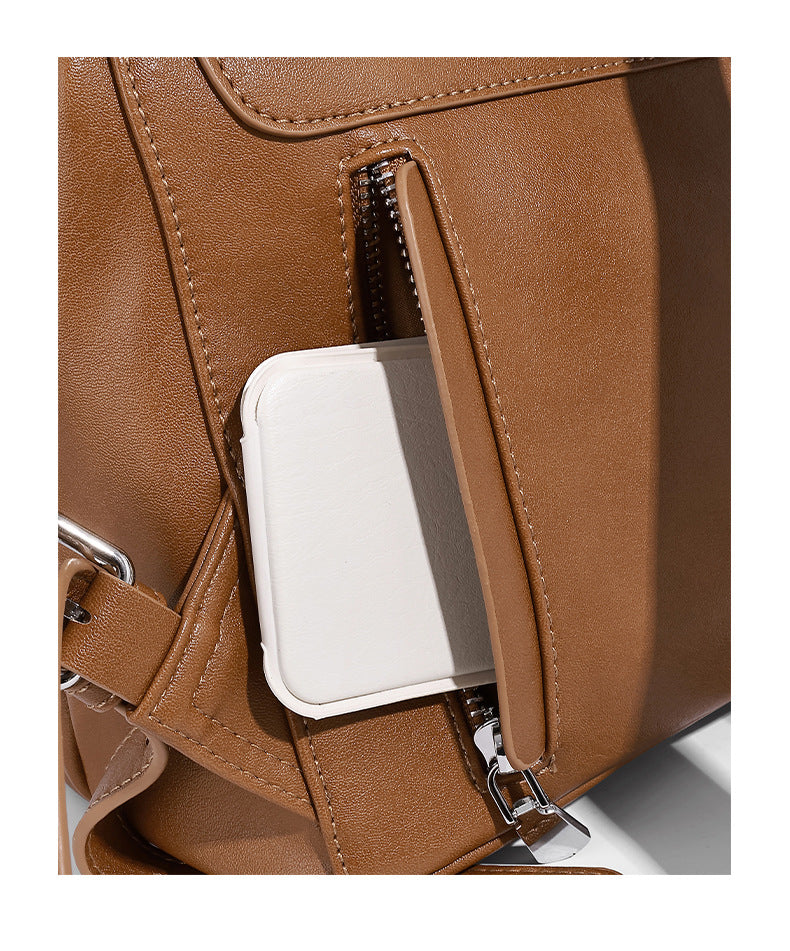 Structured tan leather-look flap backpack handbag with top handle, silver buckle hardware, and fold-over front closure