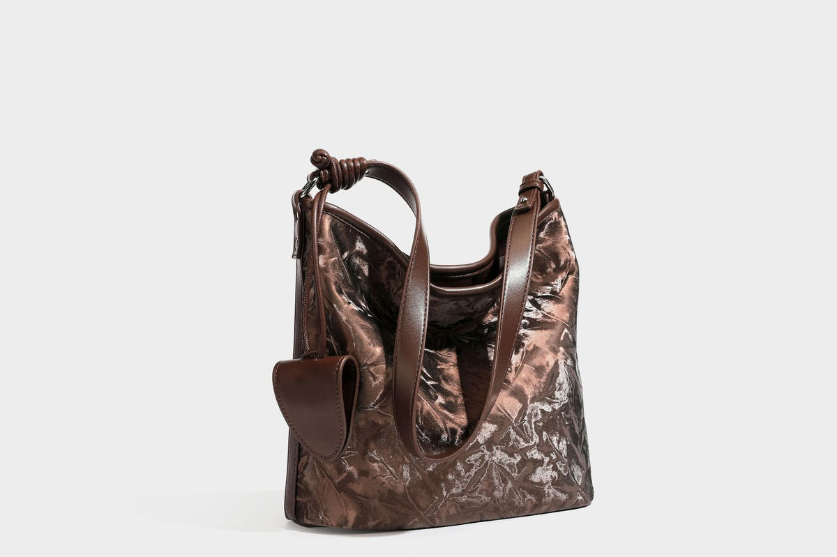 Große Hobo-Schultertasche mit Crinkle-Glanzfinish in Dunkelbraun, schmalem verstellbarem Riemen, geknoteten Beschlägen und seitlich befestigter Klappe