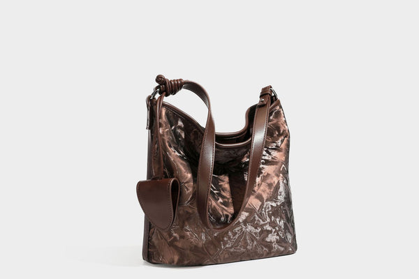 Große Hobo-Schultertasche mit Crinkle-Glanzfinish in Dunkelbraun, schmalem verstellbarem Riemen, geknoteten Beschlägen und seitlich befestigter Klappe