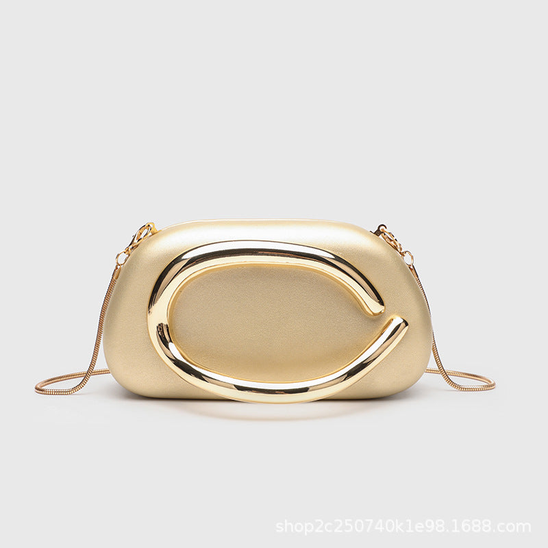 Kleine rechteckige Crossbody-Clutch mit abgerundeten Ecken, oversized poliertem C-förmigem Goldgriff und schmalem Goldkettenriemen, Detailansicht