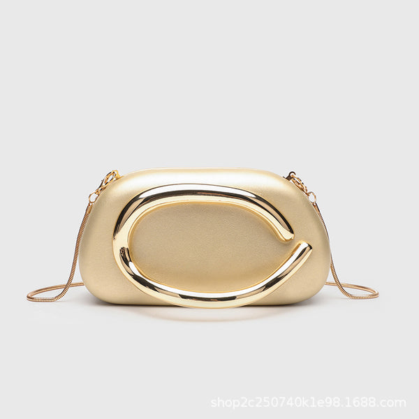 Kleine rechteckige Crossbody-Clutch mit abgerundeten Ecken, oversized poliertem C-förmigem Goldgriff und schmalem Goldkettenriemen, Detailansicht