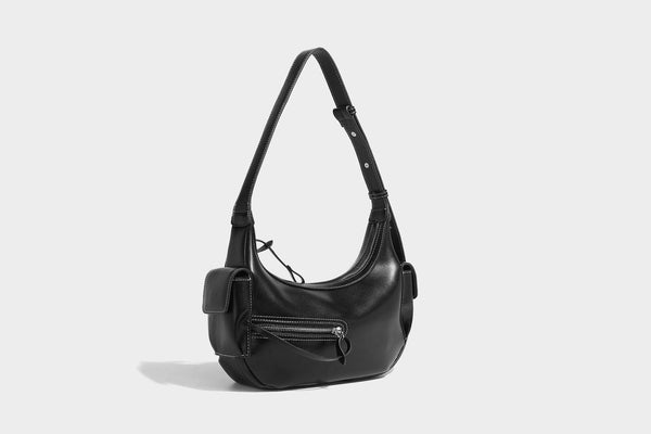 Smooth leather-look crescent shoulder bag with front zip pocket, side flap pockets, adjustable strap, and silver-tone, detail