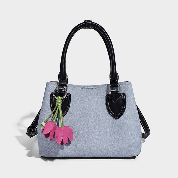 Structured light-blue denim-look tote bag with black leather-look handles, white contrast stitching, silver-tone hardware