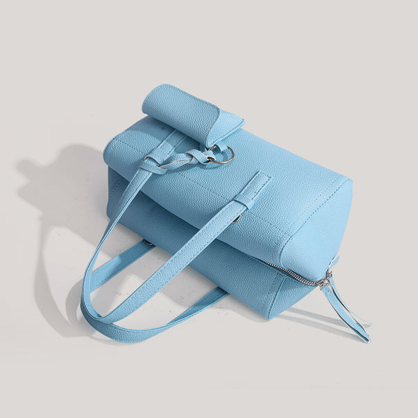 Light blue pebbled matte Boston tote bag with top handles, detachable shoulder strap, metal ring hardware, and matching mini