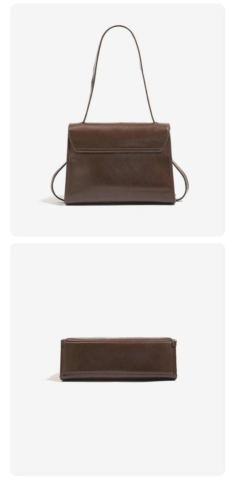 Structured trapezoidal flap satchel bag with silver-tone turn-lock clasp, decorative front strap tabs, gusseted sides, and