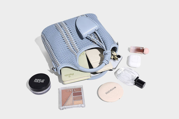Geflochtene Bucket-Tasche in Pastellblau mit geflochtenen Henkeln, vorderem Einsteckfach, Perlenanhänger und abnehmbarem Schulterriemen