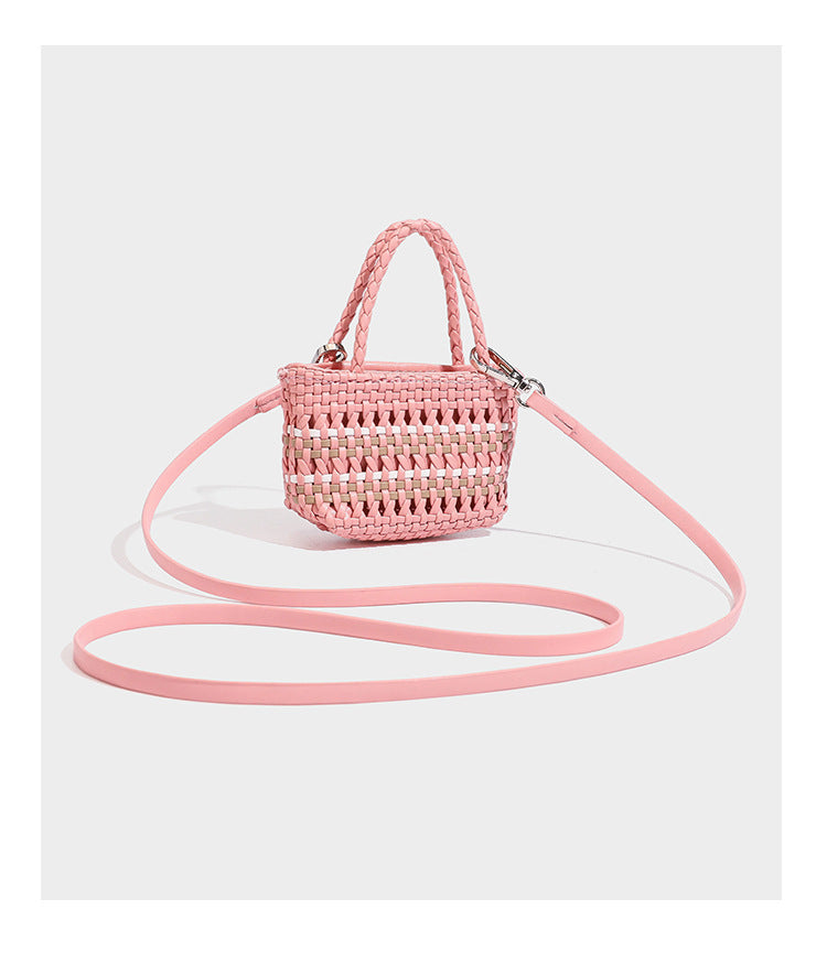Large structured woven tote bag with striped basket-weave finish, long shoulder straps, and detachable mini pouch charm